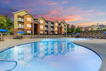 a swimming pool with an apartment building in the background